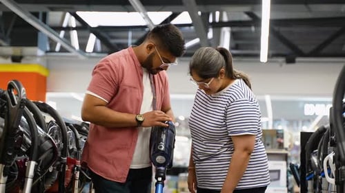 Indian Couple Choosing Vacuum Cleaner in an Electronics Tech Store