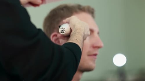 Man Getting Haircut in Barbershop with Hair Clippers