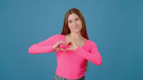Smiling Woman Making Heart Shapes with Hands