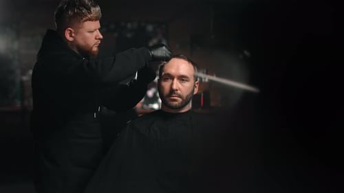 Stylish Barber Cuts Hair in Moody Setting