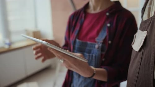 Adults Talking and Using a Tablet Indoors