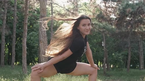 Athletic Brunette Woman Doing Stretching in a City Park