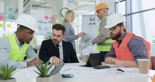 Portrait of team of man and woman engineers which brainstorming together over joint building project