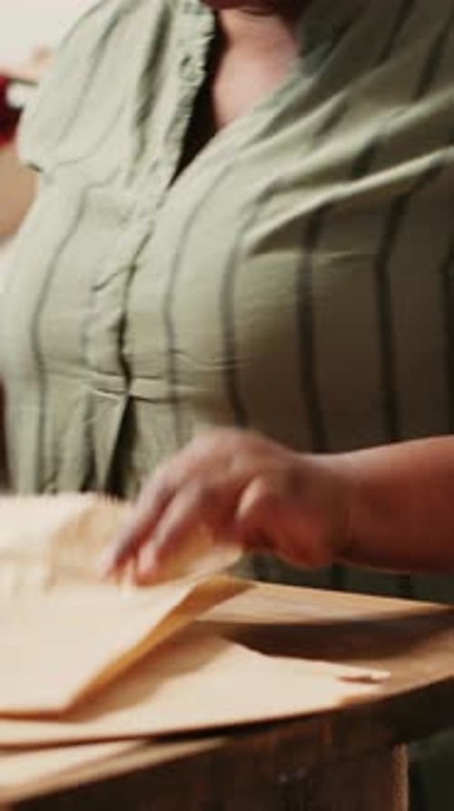 Woman Pours Pasta into Bag at Table