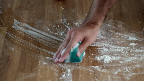 Efficient Scrubbing: Man Cleans Wooden Table with Suds. Deep Cleaning
