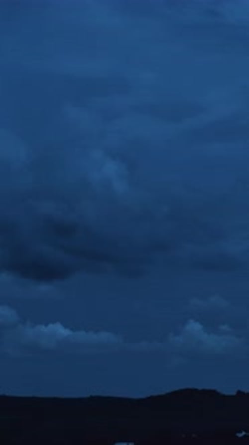 Night scene landscape of big clouds in the dark sky 4k timelapse Vertical video