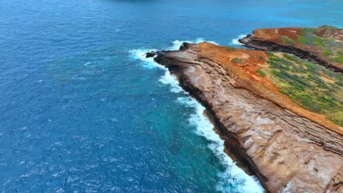 Fliegen über der felsigen Küste, die vom Wasser des Pazifischen Ozeans durchschnitten wird