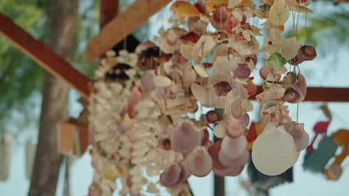 Seashell mobile hanging on tropical beach, artistic design