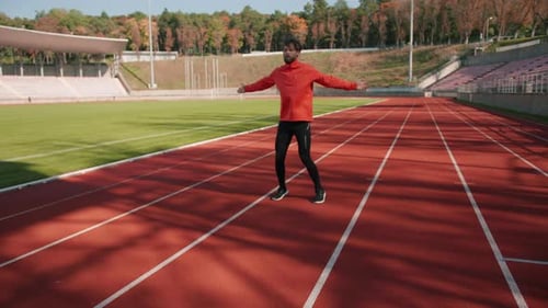 Athlete Man Stretching and Exercising on Running Track