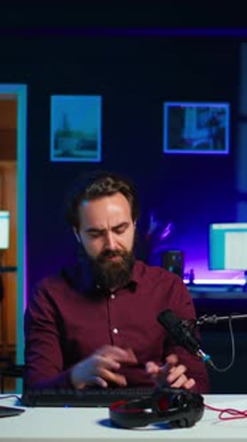 Man Sits at Desk Examining Computer Equipment