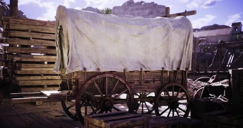 Vagón de madera cubierto que descansa en un entorno rústico al aire libre durante el día