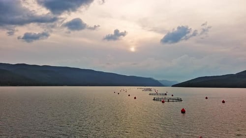 Fishing Cages for Breeding Fish in Lake in Mountain Valley of Rhodope Mountains Under Cloudy Sky