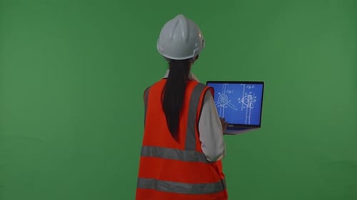 Back View Of Asian Female Engineer Looking At The Wind Turbine Blueprint In The Green Screen