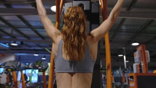 Mujer de fitness hinchando músculos haciendo ejercicios de flexiones en el gimnasio