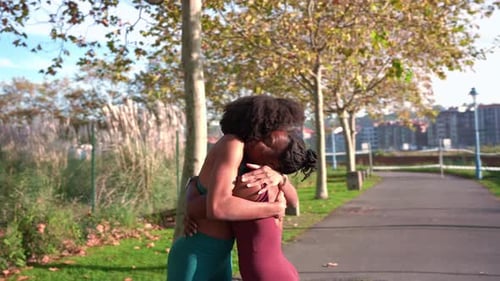 Two Black Women Embracing and High Fiving During Outdoor Workout