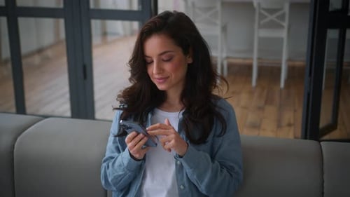 Young Woman Using Cellphone Indoors at Home
