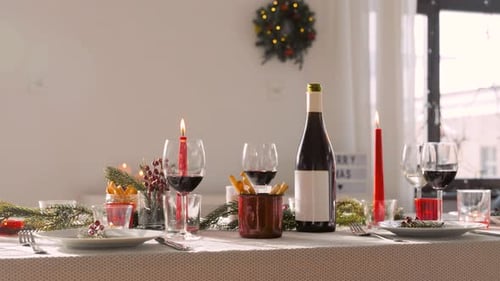 Festive Christmas Dinner Table Setting with Wine and Candles