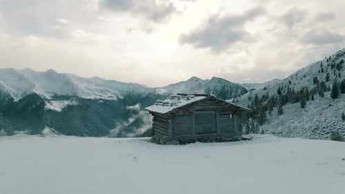 Alpine hut in front of snow covered mountains with the first fresh snow of the season. Italian Alps
