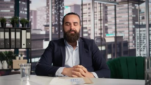 Business Man Sitting at Desk Talking in Office