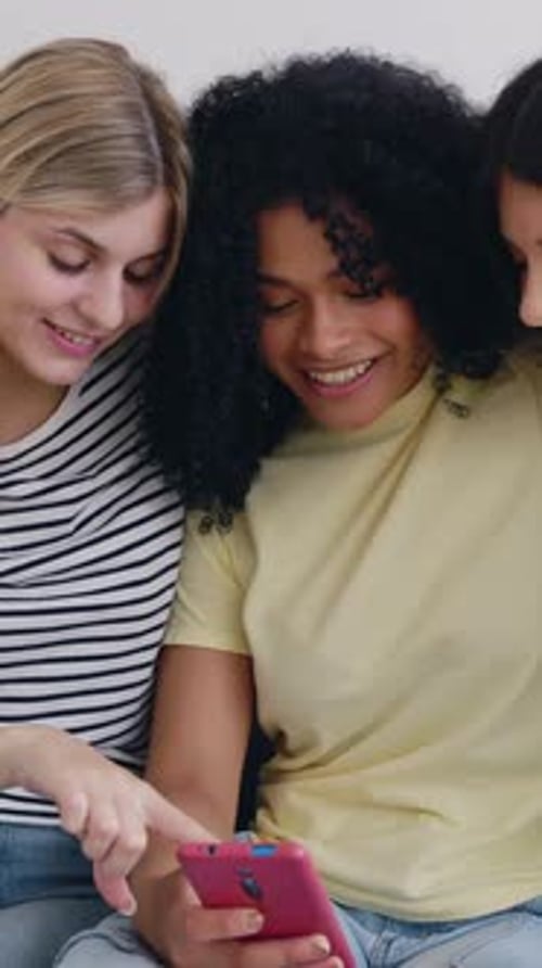 Three Friends Smiling at a Mobile Phone