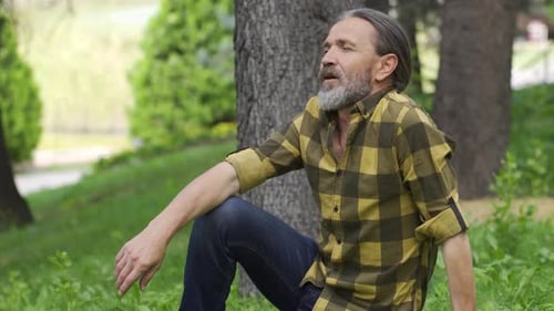 Man Relaxes on Grass in Outdoor Park Setting