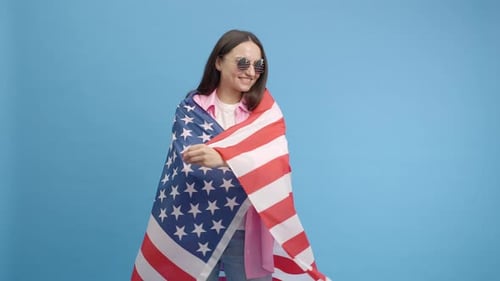 Cheerful Woman with American Flag on Blue Background