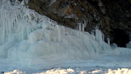 Rocky mountains covered with ice and icicles. Camera moves left to right.