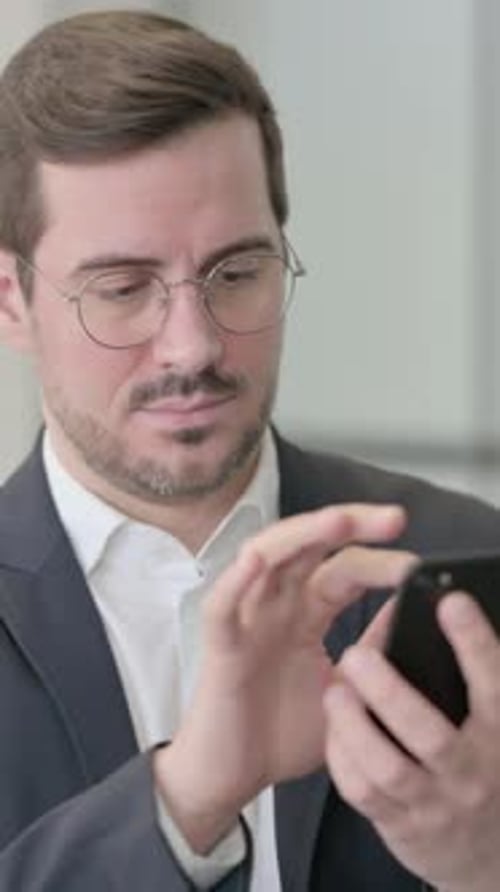 Man in Suit Using Smartphone in Vertical Video