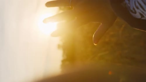 Woman Reaches for the Sun During Sunset