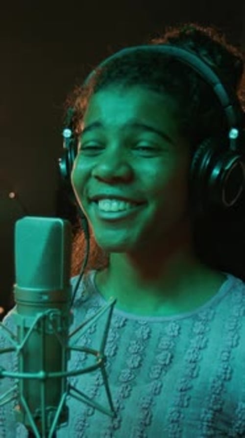 Portrait of Joyful Teen Musician Recording Song in front of Studio Microphone
