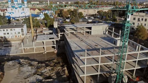 Vista desde arriba de varias grúas de construcción de diferentes alturas en un sitio de construcción durante el