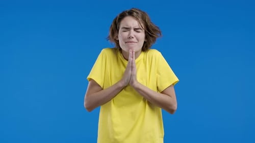 Young Woman Pleading with Clasped Hands