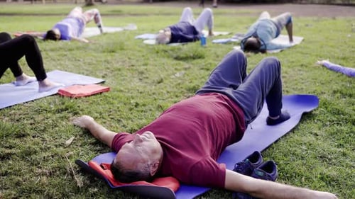 Group of senior sport people exercising during yoga workout class outdoor at park city - Fitness joy