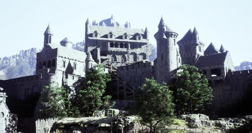 Historic Stone Castle Surrounded By Mountains in Bright Daylight