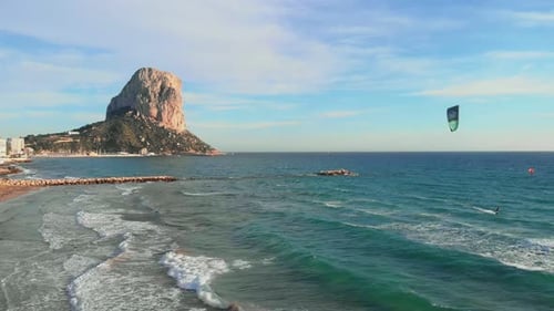 People kite surfing and windsurfing on waves on coastline of Mediterranean Sea