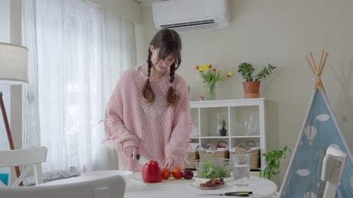 Woman Prepares Fresh Salad in Bright Kitchen