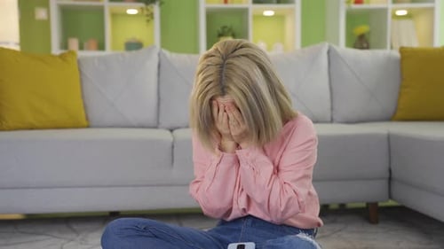 Die junge Frau ist traurig über das, was sie am Telefon gesehen hat, und weint.