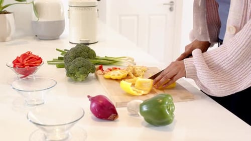 Woman Cutting Colorful Vegetables in Bright Kitchen