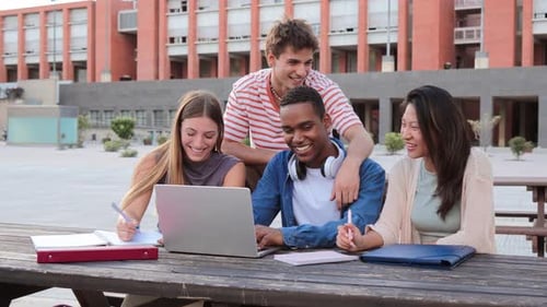 Group of Young Classmates Studying Together and Preparing a Exam Using a Laptop Browsing on Internet