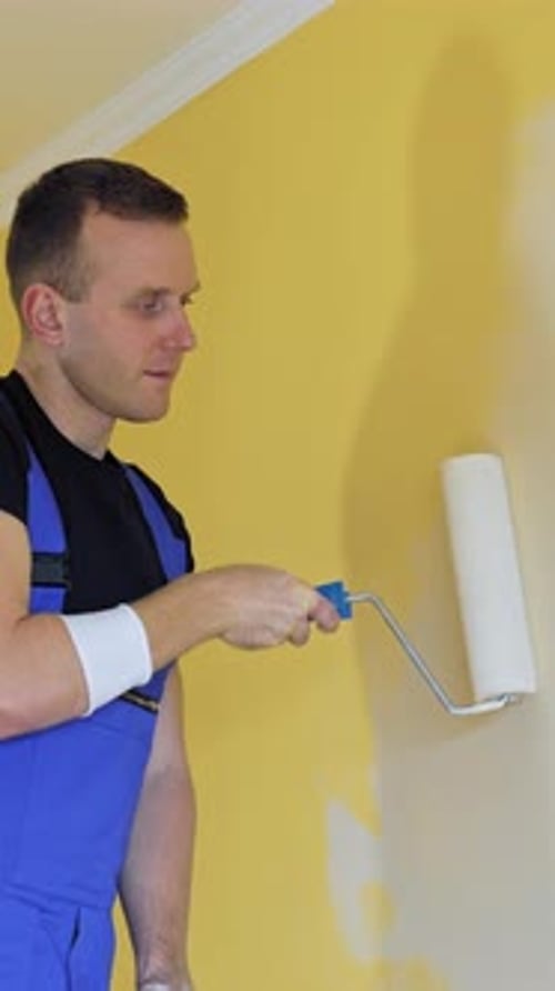 Man Painting Interior Wall with Paint Roller