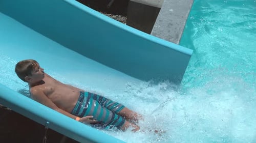 Child having fun on a water slide in summer