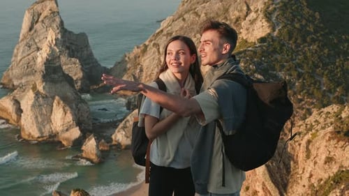 Couple amoureux profitant d'un magnifique coucher de soleil lors d'une randonnée côtière