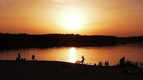 Aerial View of Orange River Surface at Sunset and Silhouettes of Vacationers on the Shore and