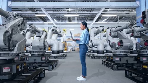 Woman Engineer with Laptop in Robotics Factory