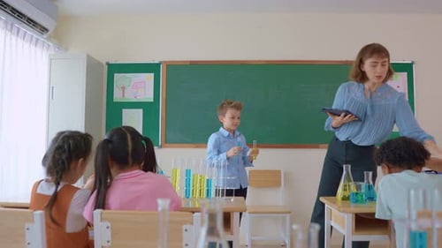 Adorable student learn with teacher in classroom at elementary school.