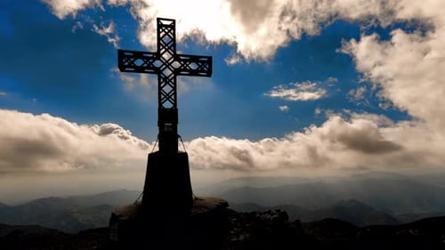 Cross On Top Of A Mountain With Moving Clouds
