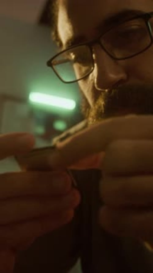 Close-up of Man Inspecting CPU Chip, While Sitting on Floor in Sunlit Room