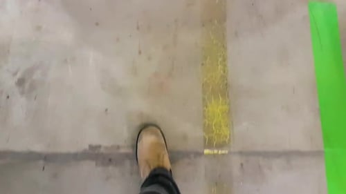 Walking with safety boots on a special designed walking path on a concrete factory shop floor. Slow