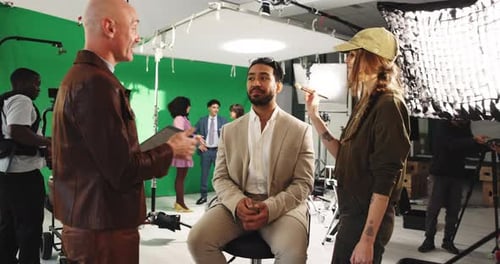 Makeup, tablet and director with man in studio with facial touchup for photoshoot or filming