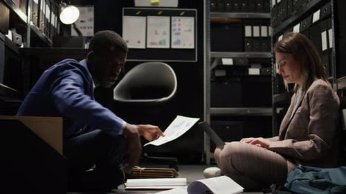 Professionals Working Late in Dim Office with Files